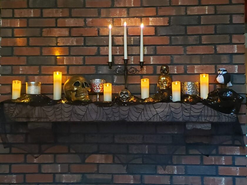 black candelabra metal candlesticks warm LEDcandles gold skull silver skull brick wall gothic candle holders