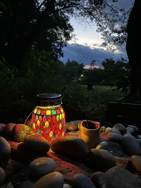 colorful warm LEDcandles closeup outdoor rocks sky woods floor candle holders
