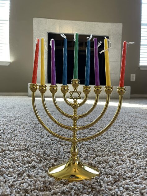 gold colorful candlesticks fireplace grey carpet closeup angle view menorah candle holders