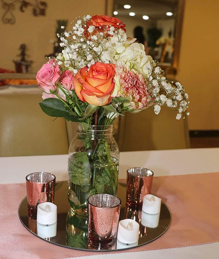 flameless candles on mirror round tray with glass vase floral centerpiece